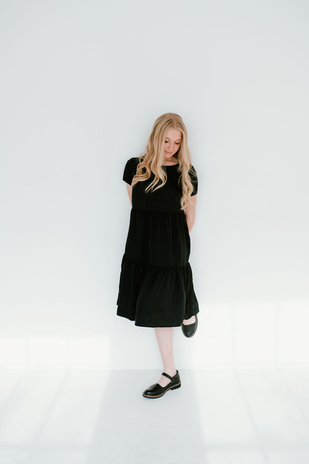 Black modest midi (right below the knee) dress with pockets.