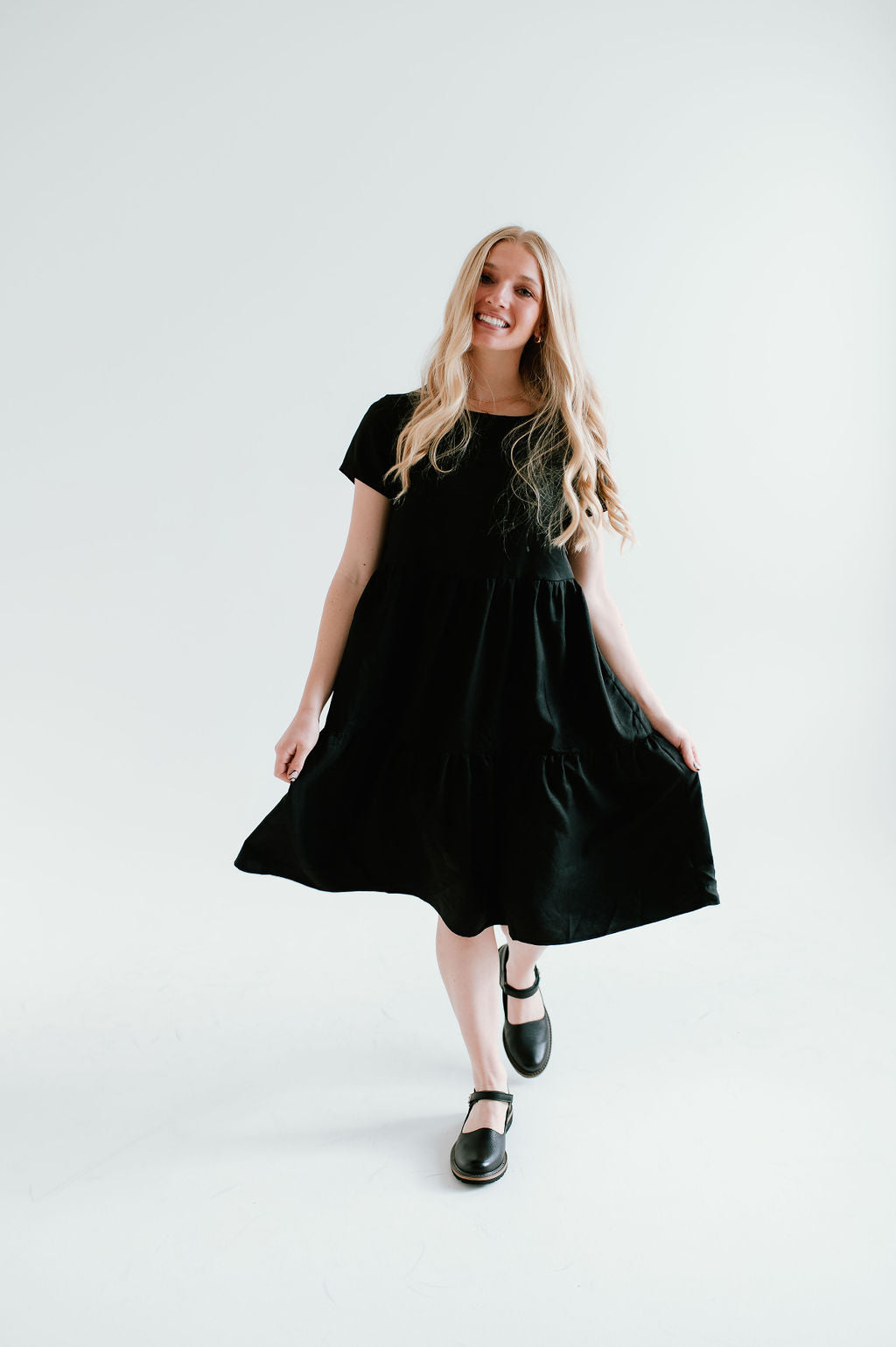 Black modest midi (right below the knee) dress with pockets.