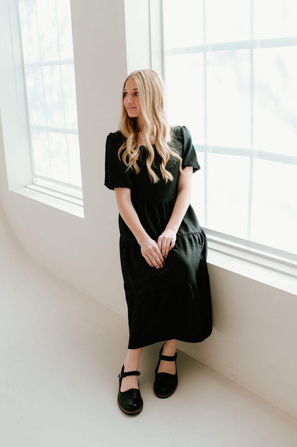 Modest black dress with short sleeves and pockets.