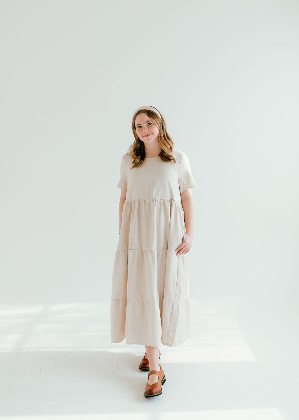 Modest light tan dress with short sleeves and pockets.