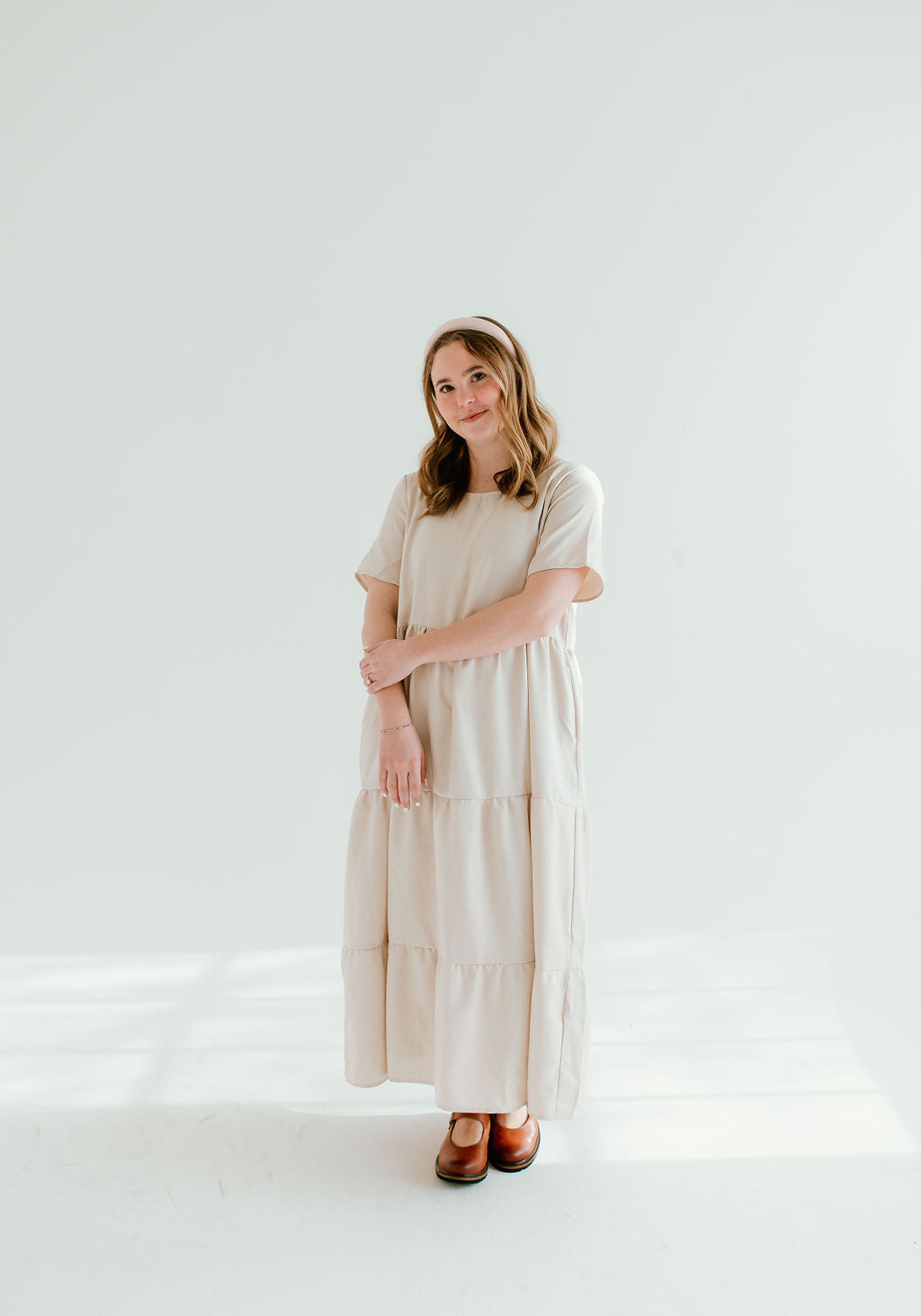 Modest light tan dress with short sleeves and pockets.