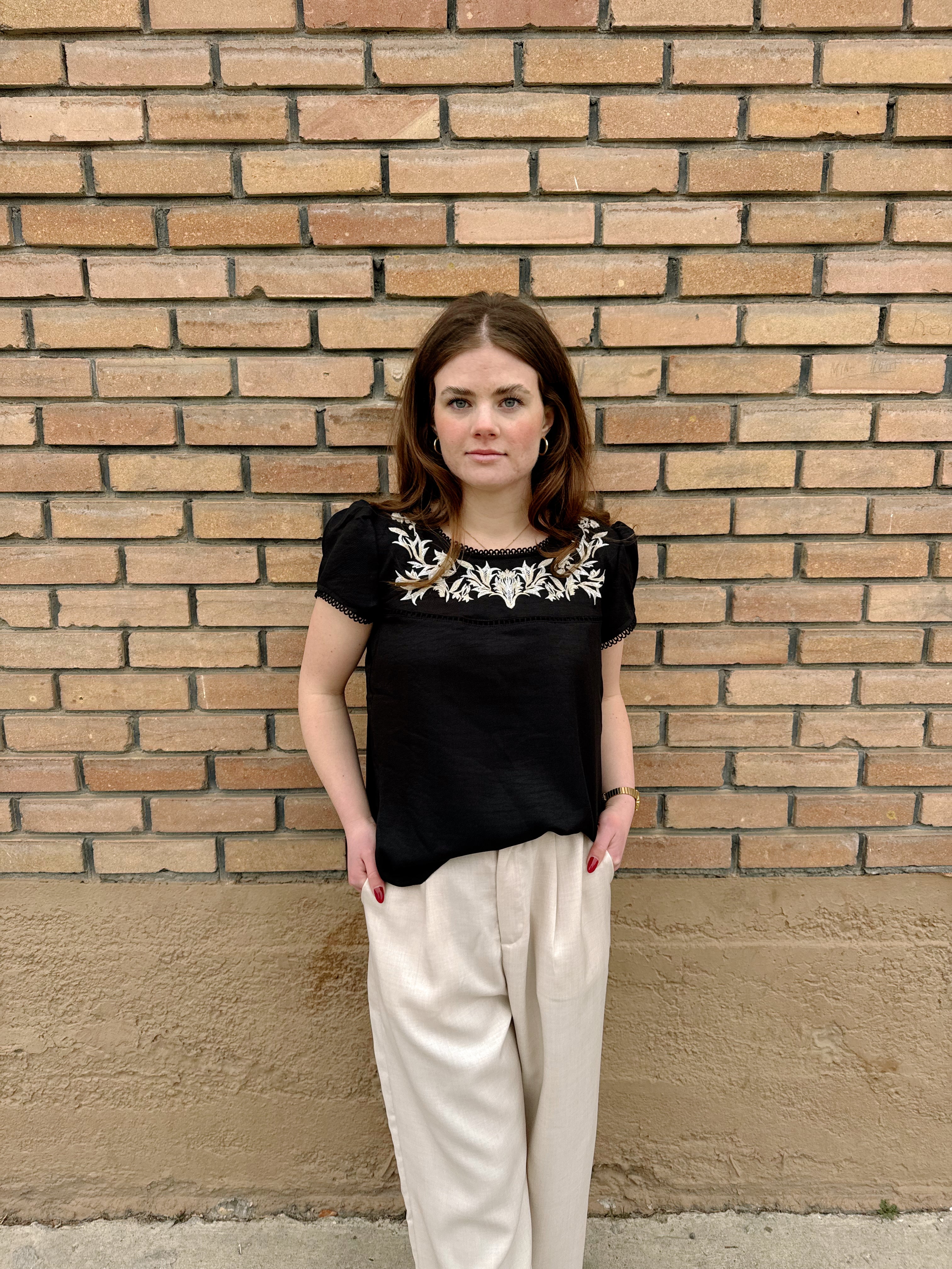 Hampton Top with embroidered floral details, worn by a model in black, from Tezza fashion collection.