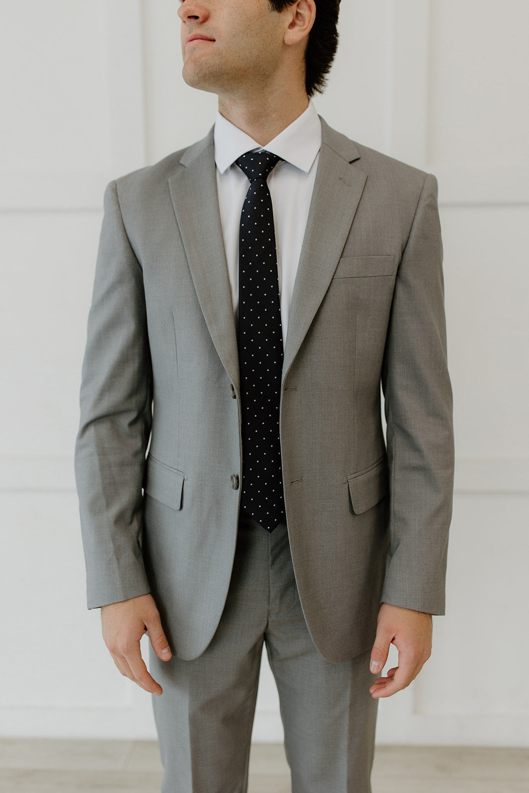 Man wear grey suit with black tie